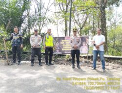 Kapolsek PUT Bersama Personel Pasang Spanduk Peringatan di Jalur Rawan Longsor dan Jalan Rusak